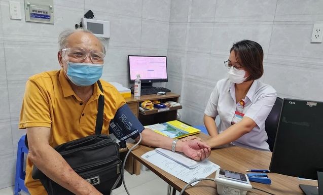 本月内为高龄人免费诊治病。图为医护人员在为一位高龄者测量血压。（图：海燕）