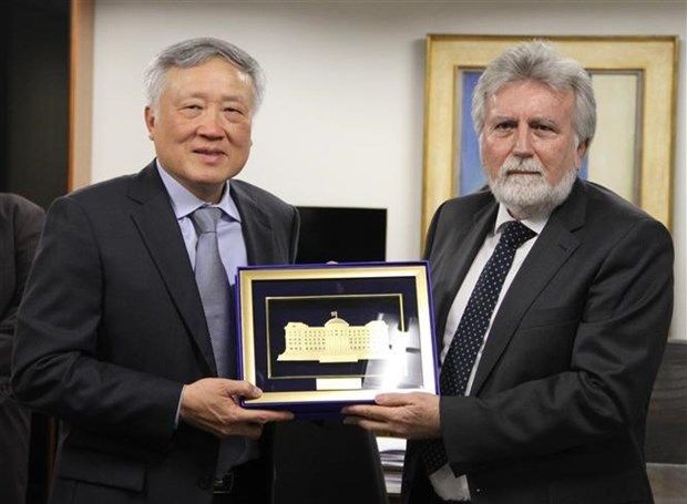 最高人民法院院长阮和平（左）向巴西联邦地区法院院长何塞·克鲁斯·马塞多赠送纪念品。（图：越通社）
