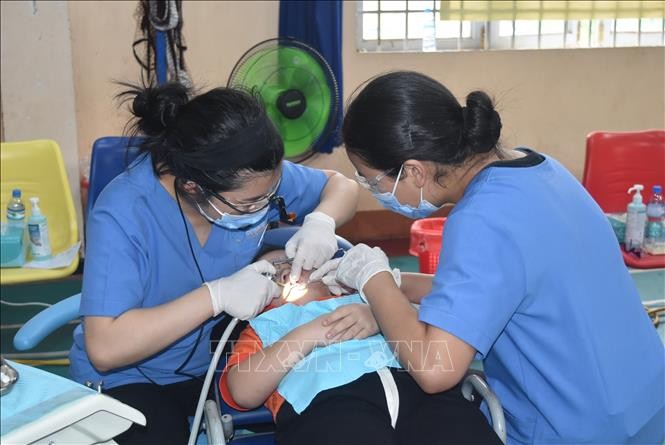 牙科医师在为一名残疾孤儿诊治牙科病。（图：越通社）