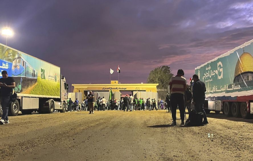 多辆载着救援物资的货车停泊在拉法口岸。（图：AP）