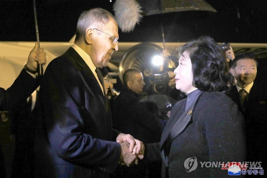 俄罗斯外长拉夫罗夫（左）与前来接机的朝鲜外务相崔善姬握手。（图：韩联社/朝中社）