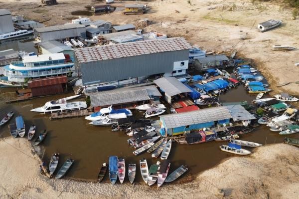 这是10月10日在巴西亚马孙州的内格罗河支流塔鲁曼河河畔拍摄的船屋（无人机照片）。巴西亚马孙地区近期遭遇严重旱情。（图：新华社）