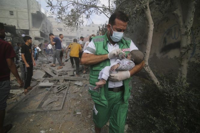 22日，在加沙地带医务人员将一名婴儿从建筑物中救出。（图：AP）