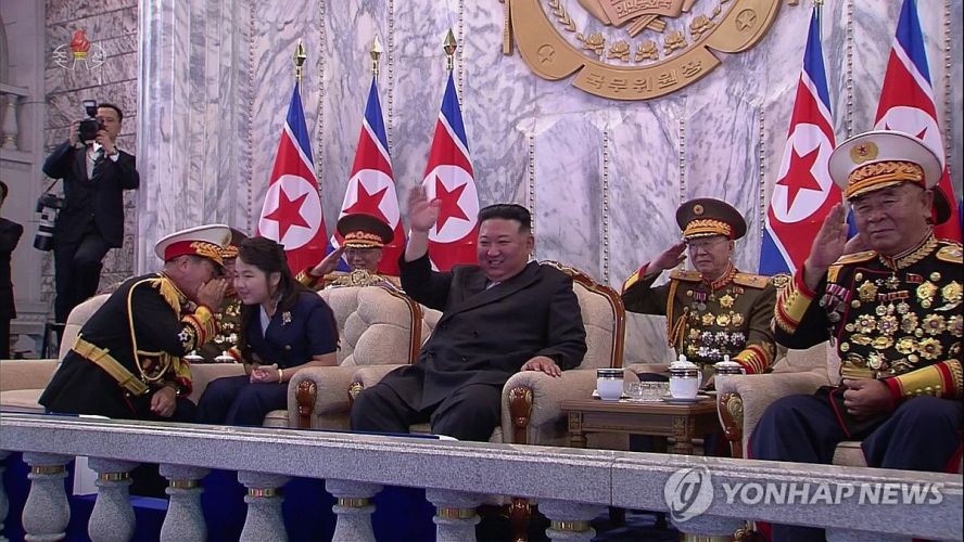 9月9日，在朝鲜庆祝建政75周年阅兵式上，劳动党军政指导部部长朴正天（左）单膝跪地同金主爱（音）交谈。（图：韩联社/朝鲜中央电视台）