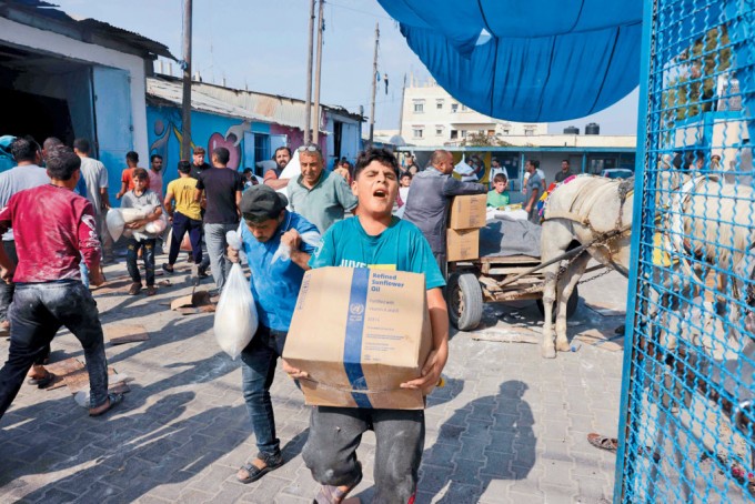 联合国救援机构在加沙地带中南部迪尔巴拉的救援物资仓库，10月28日被民众闯入抢夺面粉等物资。（图：AFP）