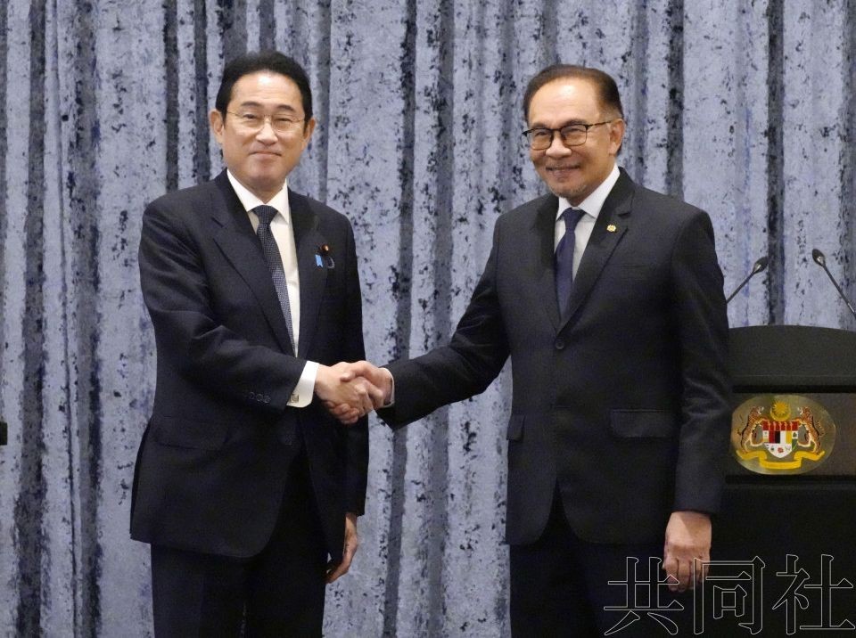 日本首相岸田文雄（左）与马来西亚总理安瓦尔结束联合记者会后握手。（图：共同社）