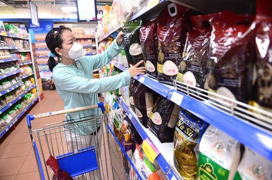 一名女性在超市选购大米。（图：互联网）