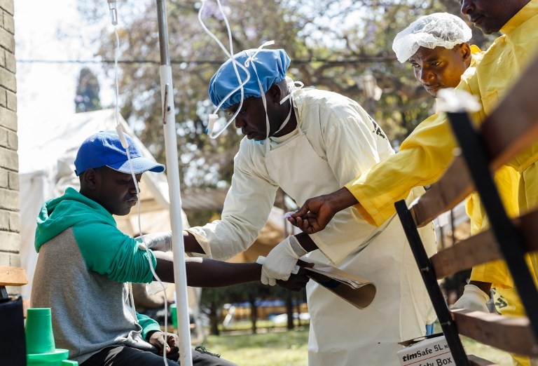 在津巴布韦哈拉雷，医护人员帮助一名霍乱患者。（图：AFP）