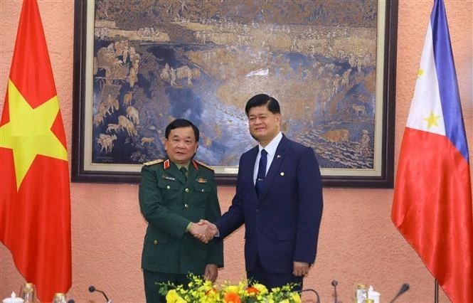 越南国防副部长黄春战上将（左）与菲律宾国防副部长伊里内奥‧克鲁斯‧埃斯皮诺握手合影。（图：越通社）