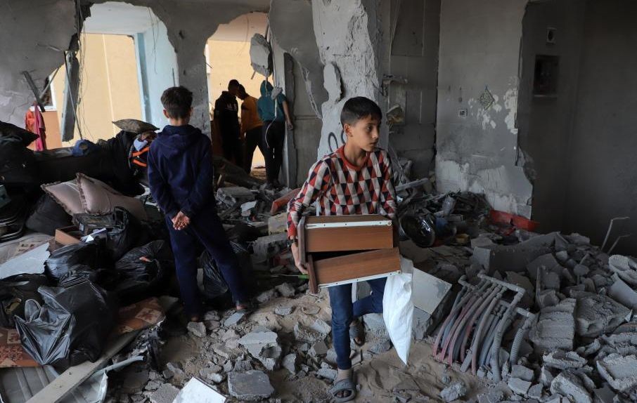 11月22日，在加沙地带南部城市汗尤尼斯，巴勒斯坦人查看遭以色列袭击后的建筑废墟。（图：新华社）