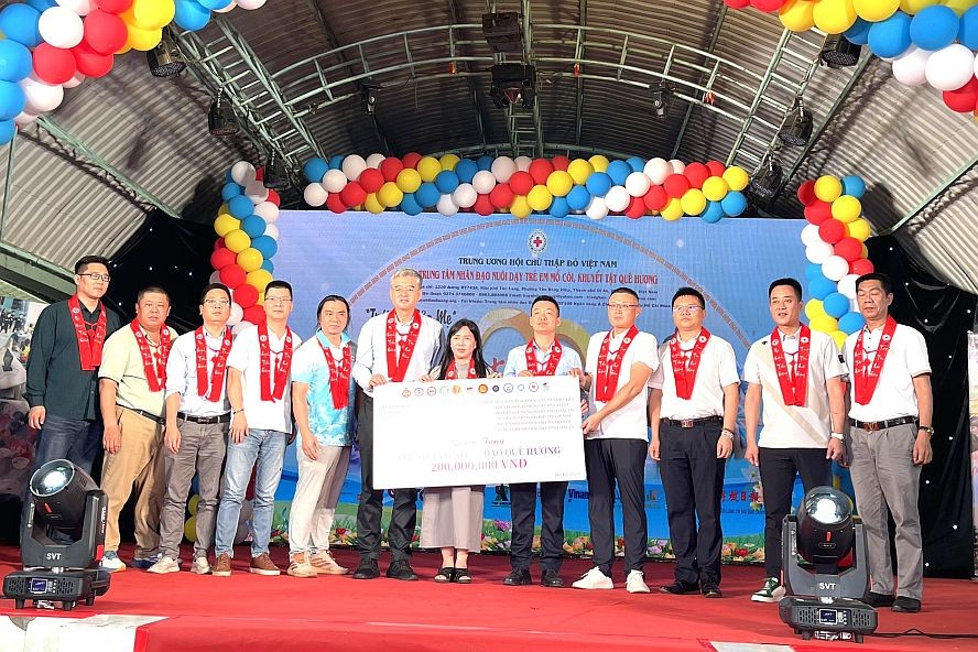 越南中国商会胡志明市分会以及各省企业联合会向故乡人道中心主任黄小香（中）捐赠2亿元。