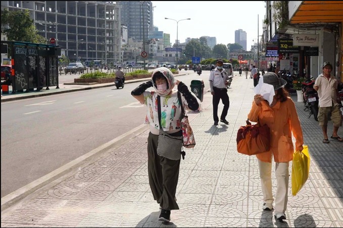 在黎利街上的游客匆往行走以躲避猛烈的阳光。