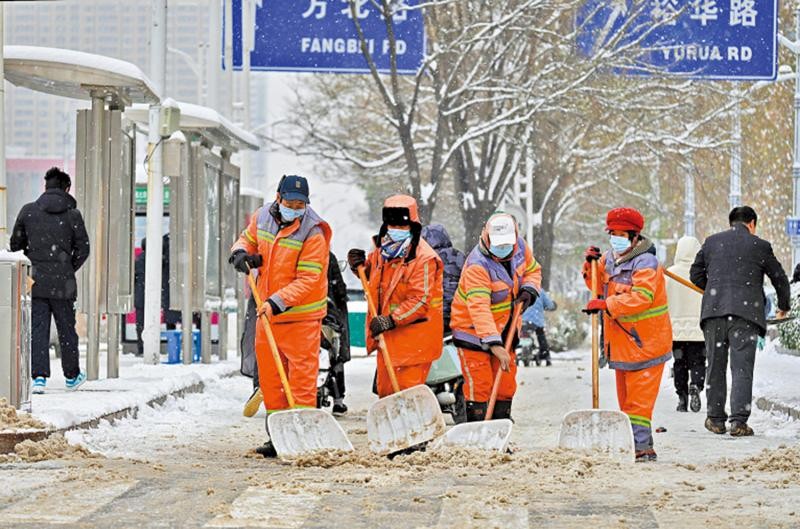 自10日以来，河北石家庄迎来多轮降雪。图为15日，环卫工人在街边清雪。（图：中新社）