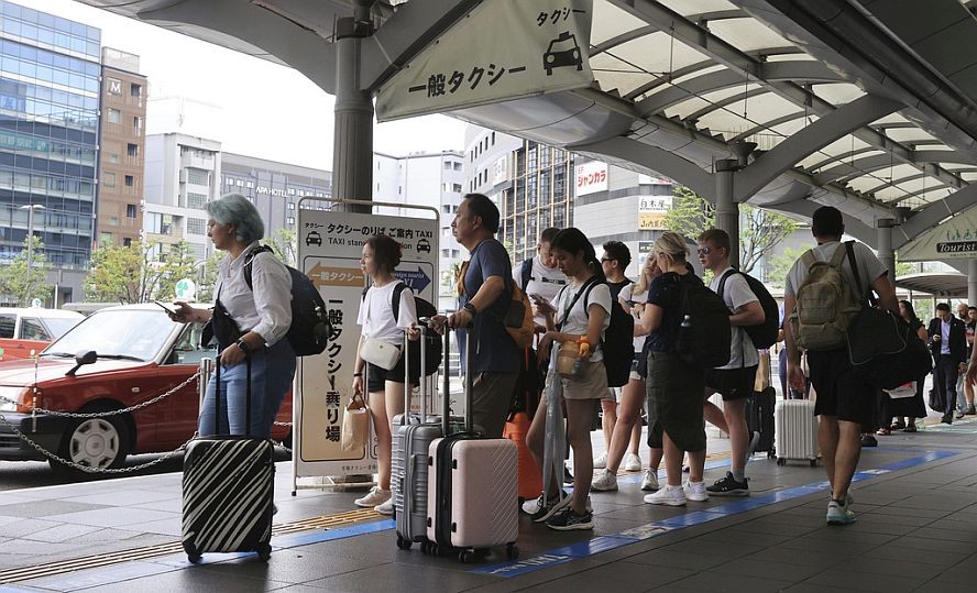 此前，许多人在京都站前排队等候出租车。（图：AP）