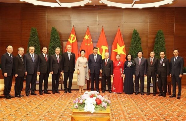 越南共产党中央总书记阮富仲和夫人与中共中央总书记、中国国家主席习近平和夫人以及双边代表合影。（图：越通社）