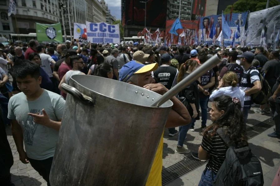 阿根廷民众背著空锅，在布宜诺斯艾利斯参加示威，抗议阿根廷新总统米莱的经济改革政策。（图：AFP） 