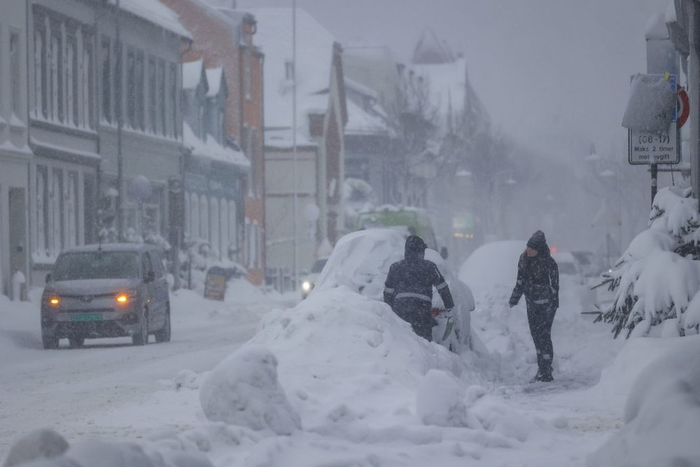 在挪威克里斯蒂安桑，民众在清除积雪。（图：AP）