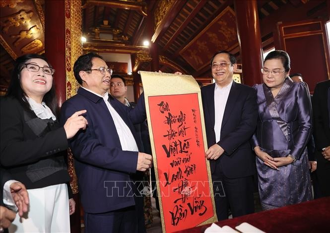 政府总理范明政（左二）在玉山寺里向老挝总理宋赛‧西潘敦赠送书法作品一幅。（图：越通社）