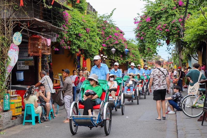 国际游客乘坐三轮脚踏车游逛会安古埠。（图：互联网）