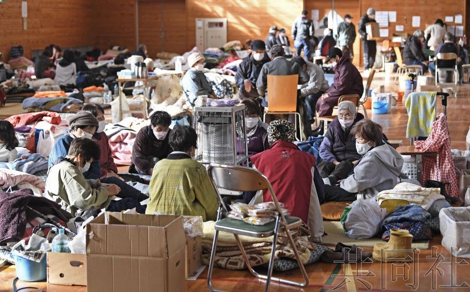 图为石川县穴水町的疏散点内取暖的灾民。（图：共同社）