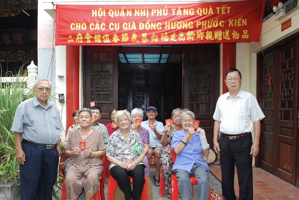 二府会馆副理事长谢忠成、彭志光向诸位高龄乡亲赠送岁暮礼物。
