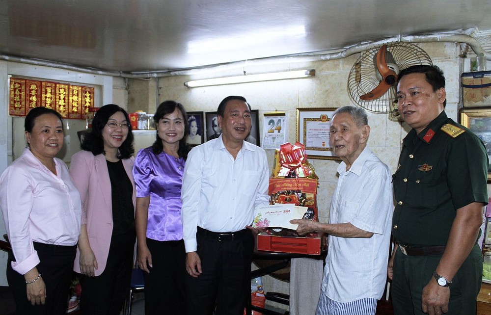 市人民议会副主席范成坚（左四）向华人老党员刘天云赠送贺年礼物。