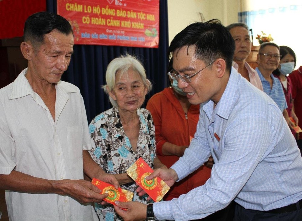 华文《西贡解放日报》编委文忠孝向贫困者赠送礼物。