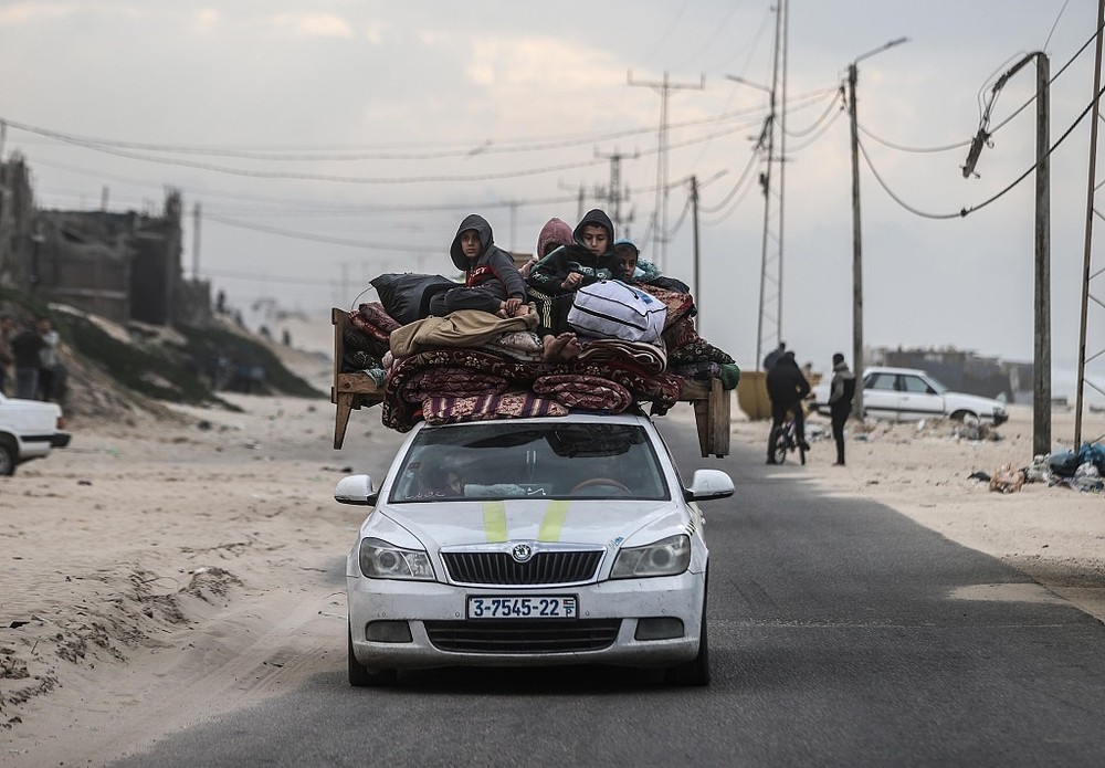 当地时间2024年1月23日，加沙地带汗尤尼斯，巴勒斯坦人，包括儿童，带着他们的物品用一辆车离开家园，逃离以色列的袭击。（图：互联网）