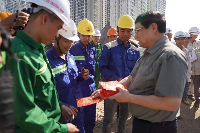 政府总理范明政向正在途经本市的环市三路施工场地工人与劳动者拜年。（图：黄雄）