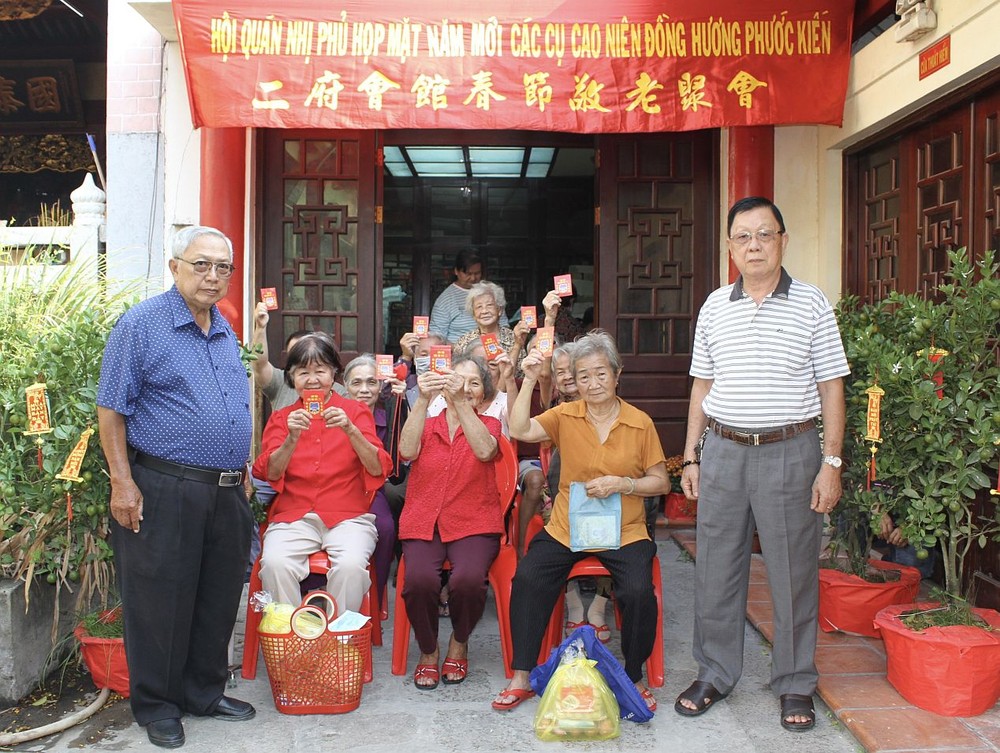 二府会馆副理事长谢忠成（右）、彭志光（左）向诸位高龄乡亲赠送春节敬老礼物。