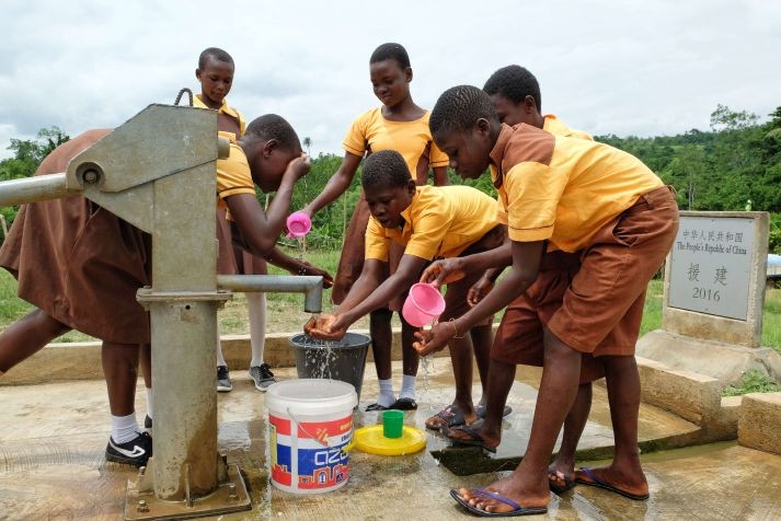 图为2018年6月18日，在加纳东部省古阿由兹村，学生从中国援建的水井打水。（图：新华社）