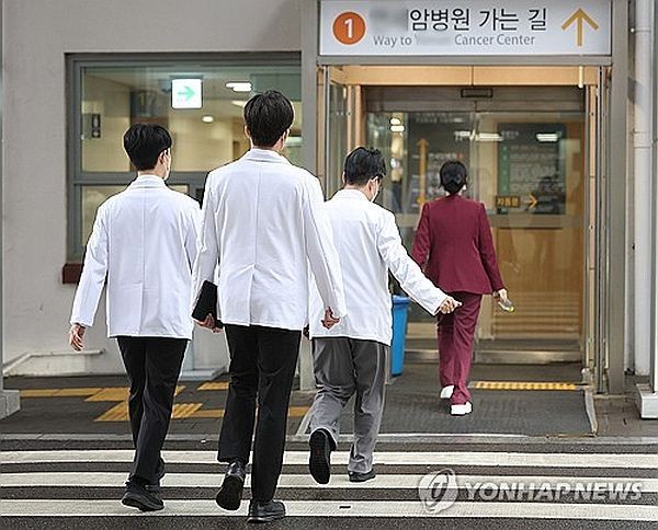 2月19日，在首尔一家大学医院，医生走在医院门口。（图：韩联社）