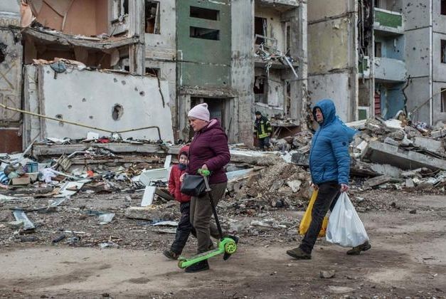 在乌克兰北部的切尔尼希夫，人们走过被炸弹摧毁的建筑。（图：联合国开发署）