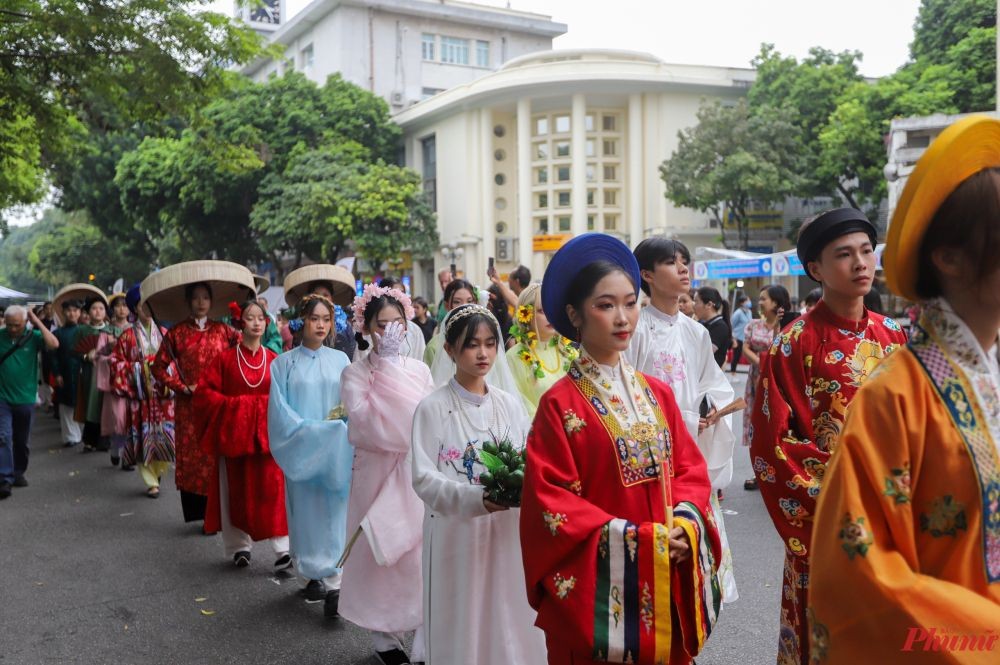 参加“百花步行”的人穿上传统服饰在街上遊行。