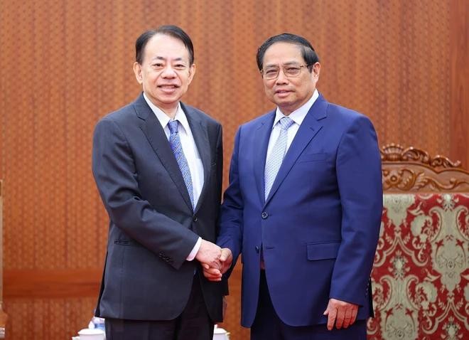 政府总理范明政（右）与亚洲开发银行行长浅川雅嗣握手合影。（图：越通社）