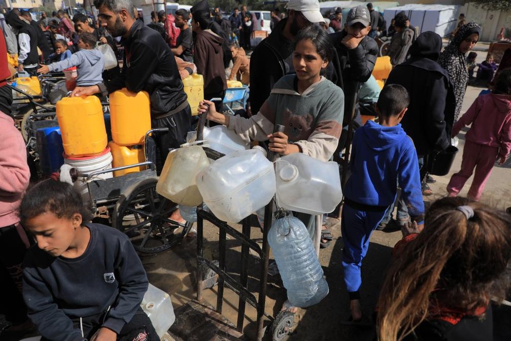 在加沙地带南部城市拉法，巴勒斯坦人等待打水。（图：新华社）
