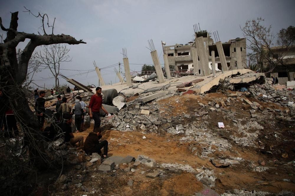 在加沙地带南部城市拉法，人们查看以色列空袭后的废墟。（图：新华社）