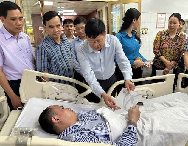 越南劳动总联团副主席潘文英与工作团亲王医院探望一名遇险获救的煤矿工人。（图：何英）