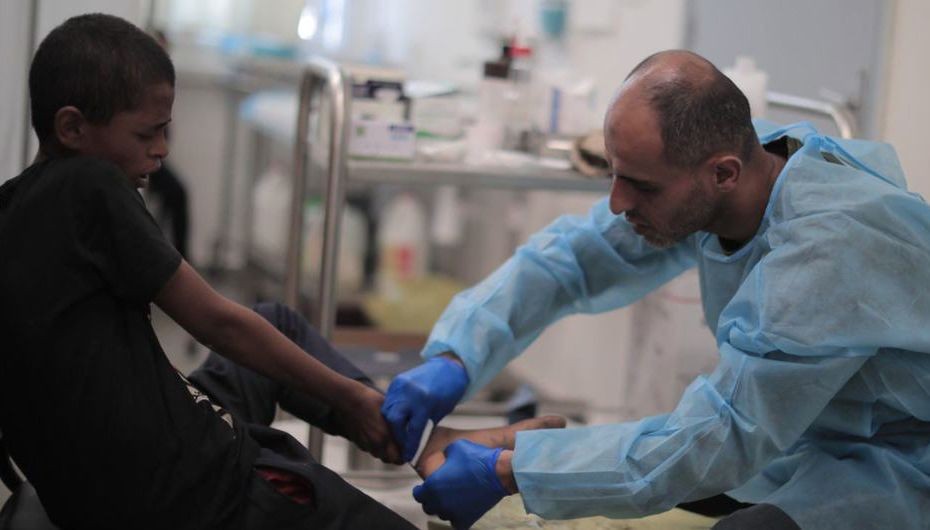 联合国近东救济工程处工作人员在加沙为男孩提供医疗服务。（图：联合国）