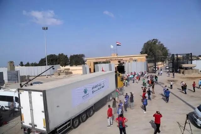 在拉法口岸埃及一侧，载有人道救援物资的货车准备通过拉法口岸前往加沙地带。（图：新华社）
