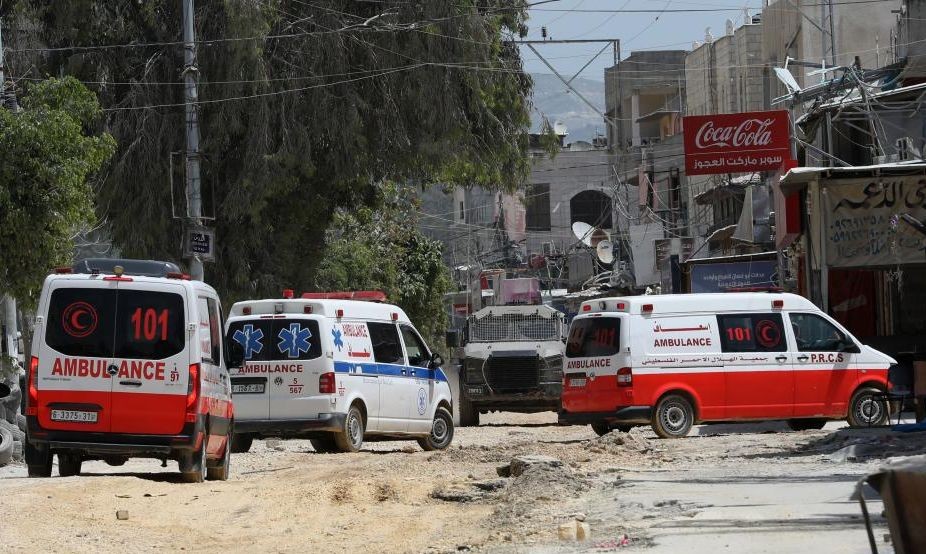 4月20日，在约旦河西岸城市图勒凯尔姆，以色列军车阻止救护车进入冲突现场。（图：新华社）