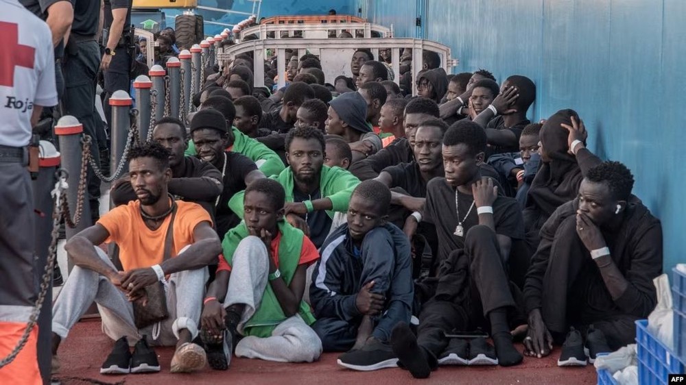 图为 2023年10月12日移民在西班牙下船后坐在地上。（图：AFP）