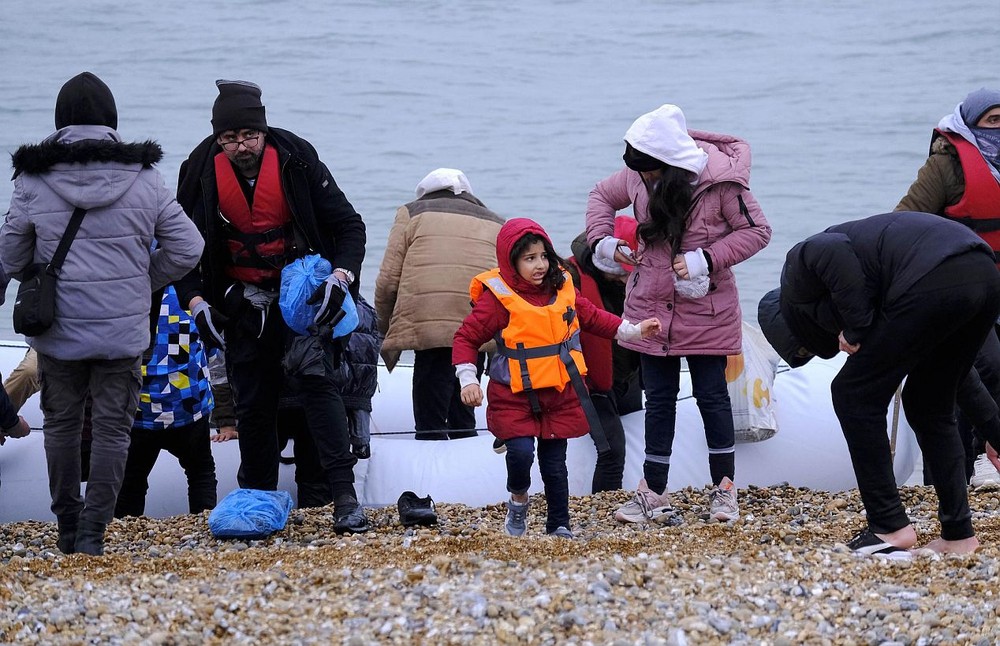 移民乘船抵达英国邓杰内斯角海岸。（图：新华社）