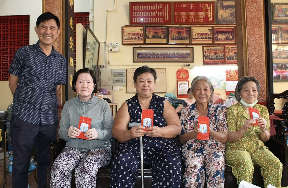 海南会馆第四十三届理事长林明辉（左一）向孤寡贫困乡亲送出关怀。