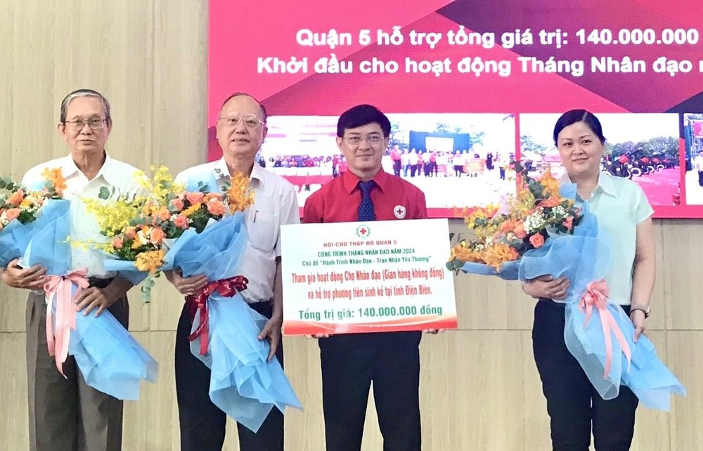 第五郡红十字会主席黎勋丰（右二）向各华人会馆赠送鲜花表示感谢。