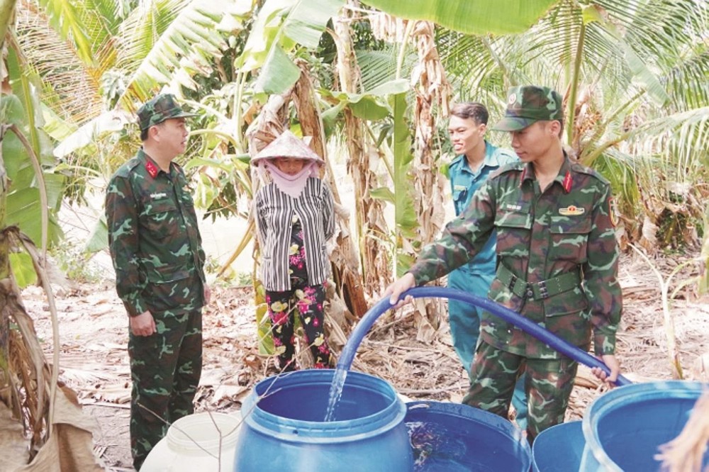 坚江省军事指挥部干部、战士辅助为江城县居民提供生活用水。