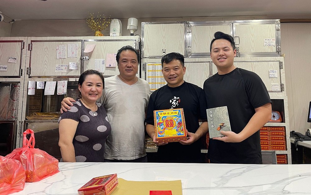 赵明合饼家第四代传人赵家安（右一）指导员工制作朥饼。