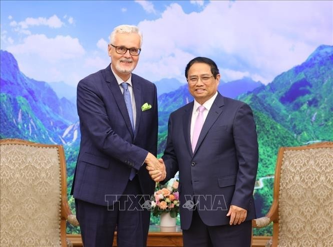 政府总理范明政（右）会见前来拜别的德国驻越南大使吉多·希尔德纳。（图：越通社）