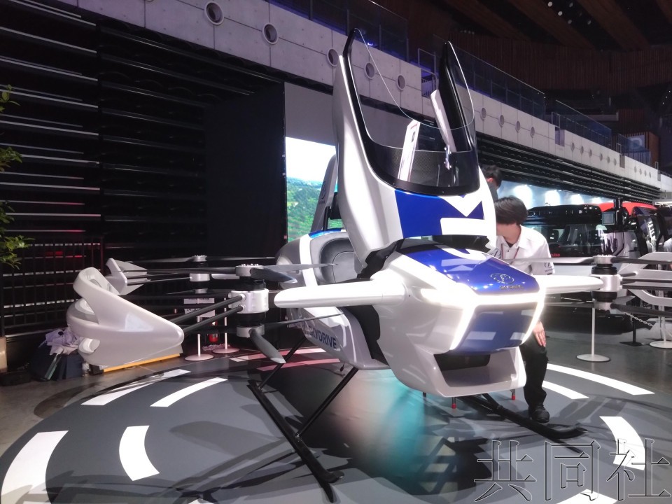 图为 5月21日在东京都江东区展示可试乘的SkyDrive公司的“空中飞行汽车”模型机。（图：共同社）