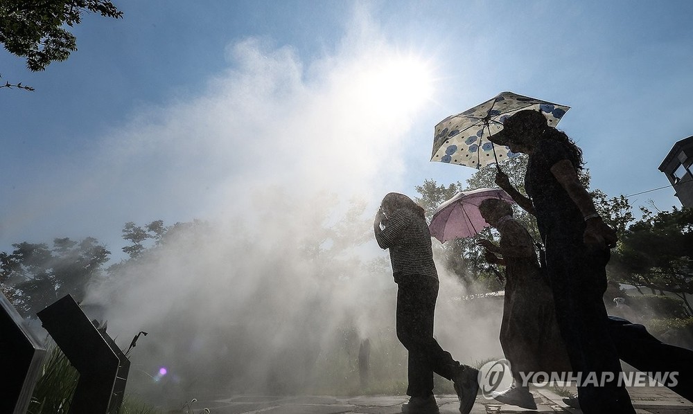 6月18日，在大邱市，市民打着阳伞出行。（图：韩联社）
